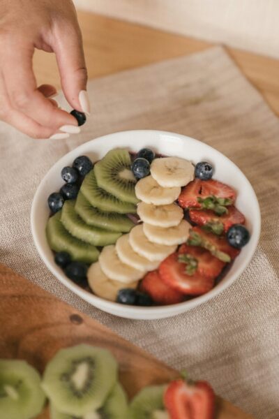 A delicious and healthy fruit bowl featuring kiwi, banana, strawberries, and blueberries. Perfect for a fresh breakfast.
